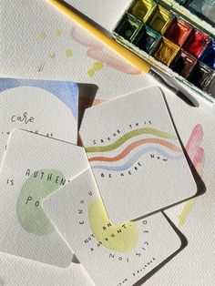 four cards with different colors on them next to some watercolors