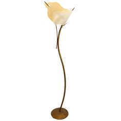 a white flower on a metal stand with a light brown base and two flowers in the center