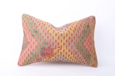 an orange and pink pillow on a white background