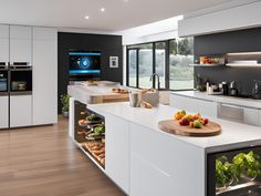 a modern kitchen with white cabinets and counter tops, along with lots of fresh fruits and vegetables