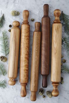 three different types of wood carving tools next to pine cones and evergreen needles on a marble surface