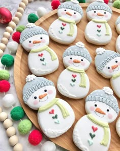 decorated cookies with snowmen on a wooden platter