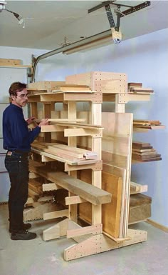 a man standing next to a shelf filled with wooden shelves