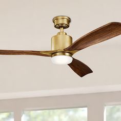 a ceiling fan with wooden blades in a room