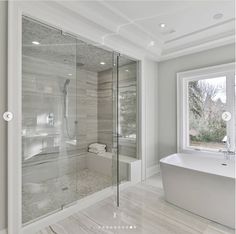 a large white bathroom with a glass shower door and bathtub in it's corner