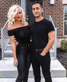 a man and woman standing next to each other in front of a building with stairs