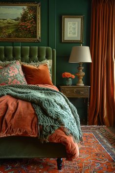 a bedroom with green walls and an orange bed spread on top of the headboard