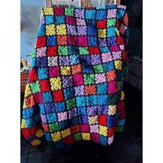 a multicolored crocheted blanket sitting on top of a chair