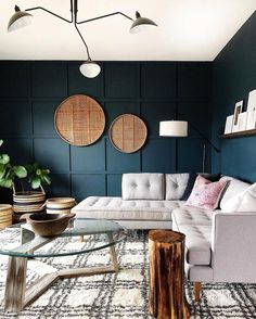 the living room is decorated in blue and gray with pops of color on the walls