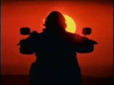 the silhouette of a person riding a motorcycle with the sun in the background and red sky