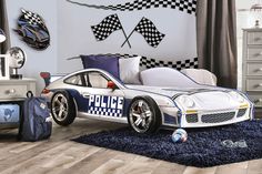 a police car shaped bed in a child's bedroom with checkered wallpaper