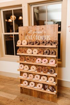 a wooden sign that says all you need is love and doughnuts on it