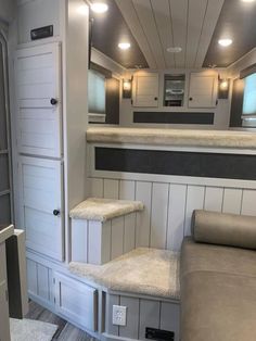 the interior of a recreational vehicle with stairs leading up to the kitchen and living room