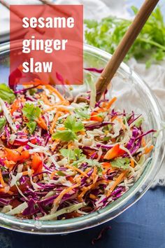 a glass bowl filled with coleslaw slaw and topped with carrots, red cabbage