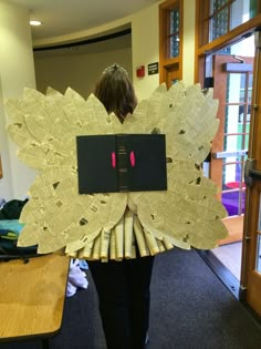 a woman is holding up a piece of paper that looks like a flower