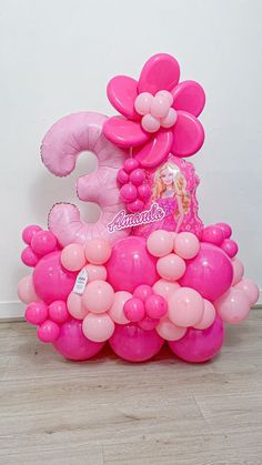 pink balloons in the shape of an elephant with a princess figure on its back, sitting on top of a wooden floor