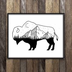 a black and white drawing of a bison with mountains in the background on a wooden wall