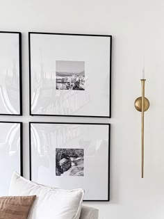 three black and white pictures hang on the wall next to a couch with two pillows