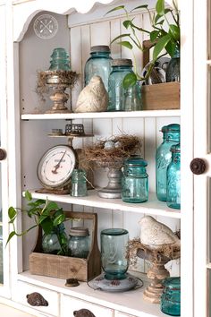 an old china cabinet is filled with glass jars and other things to decorate the hutch