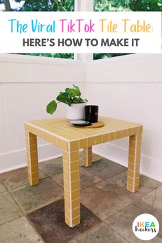 a small table with a plant on it in front of a window and a potted plant