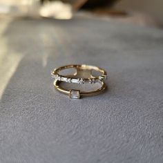 two gold rings sitting on top of a table