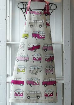 an apron hanging on a white ladder with pink and green campervans all over it