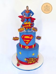 a three tiered cake decorated with supermans and stars