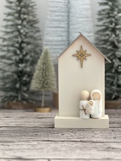 a nativity scene with a star on the roof and trees in the back ground