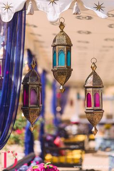 three hanging lanterns with colorful lights on them