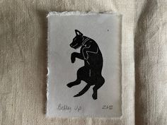 a piece of cloth with a drawing of a dog on it's back and the words baby up next to it