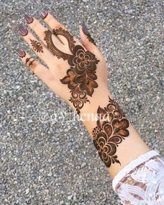 a woman's hand with henna tattoos on it and her hands painted brown