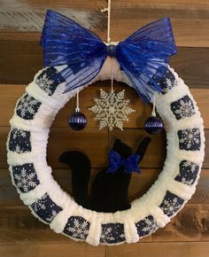 a snowflake wreath with a black cat hanging from it