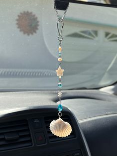 a car dashboard with a shell hanging from it's center console and beads on the front