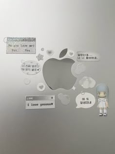 an apple sticker on the back of a silver laptop with some tags attached to it