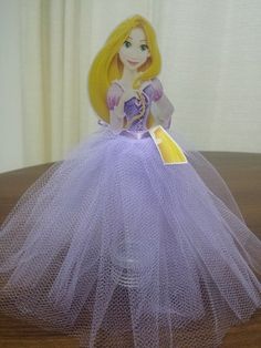 the doll is wearing a purple dress and has a tag in it's hand