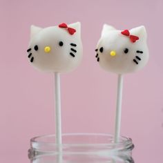 two hello kitty lollipops sitting on top of each other in a glass cup