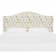 an upholstered headboard on a bed with white linens and green floral wallpaper