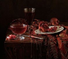 a painting of pomegranates on a table next to a glass of wine