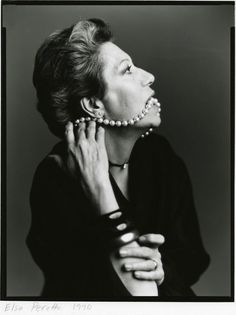 black and white photograph of a woman with pearls on her neck, looking to the side