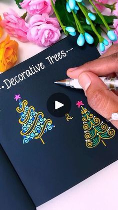 a person is writing on a card with flowers in the background