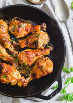 chicken wings in a skillet with parsley on the side