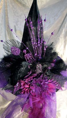 a purple and black hat with feathers on it