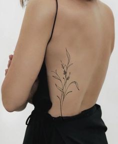 the back of a woman's body with a flower tattoo on it