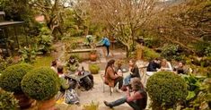 a group of people sitting around each other in a garden