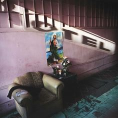 a living room with a chair and painting on the wall