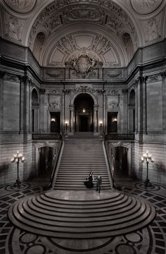 two people are sitting on the stairs in an old building with marble floors and walls