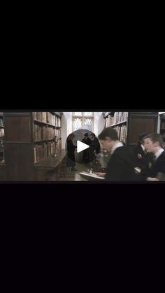 a group of people standing in front of bookshelves