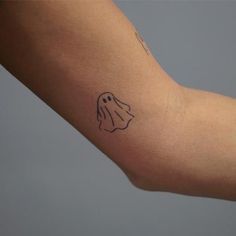 a person's arm with a ghost tattoo on the left side of their arm