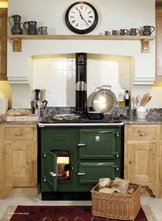 a green stove in a kitchen with a clock on the wall above it's burner