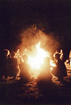 a group of people standing around a fire